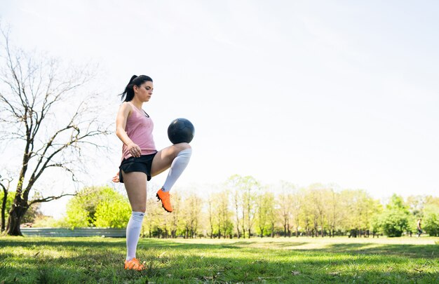 Portret van jonge vrouwelijke voetballer die en vaardigheden op voetbalgebied opleiden oefenen. Sport concept.