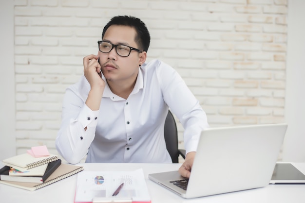 Portret van jonge zakenman zitten aan zijn bureau