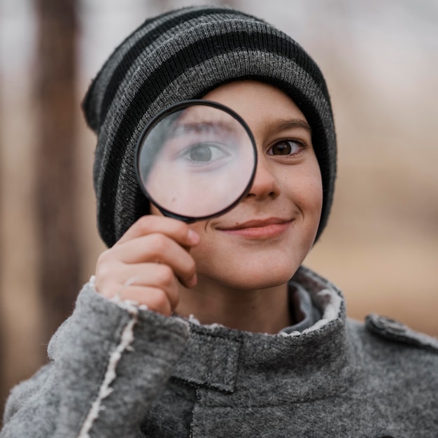 Portret van kleine jongen die door meer magnifier kijkt