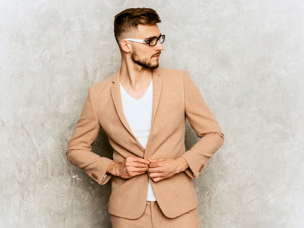 Portret van knap het glimlachen hipster zakenmanmodel die toevallig beige kostuum dragen.