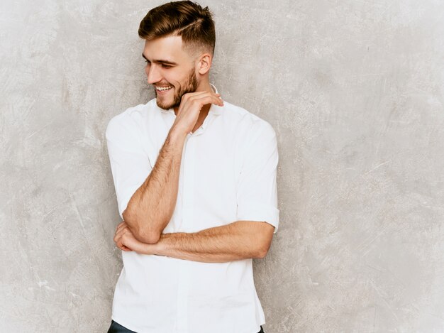 Portret van knap het glimlachen hipster zakenmanmodel die toevallig de zomer wit overhemd dragen.