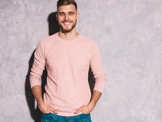 Portret van knap het glimlachen hipster zakenmanmodel die toevallige de zomer roze kleren dragen.