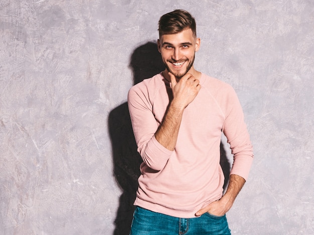 Portret van knap het glimlachen hipster zakenmanmodel die toevallige de zomer roze kleren dragen.