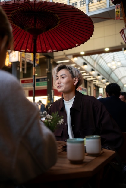 Gratis foto portret van knappe aziatische man op een reünie van vrienden