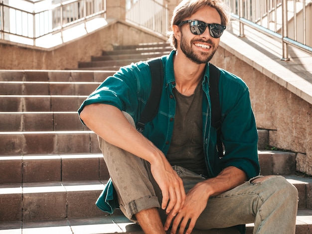 Portret van knappe glimlachende stijlvolle hipster lamberseksueel model