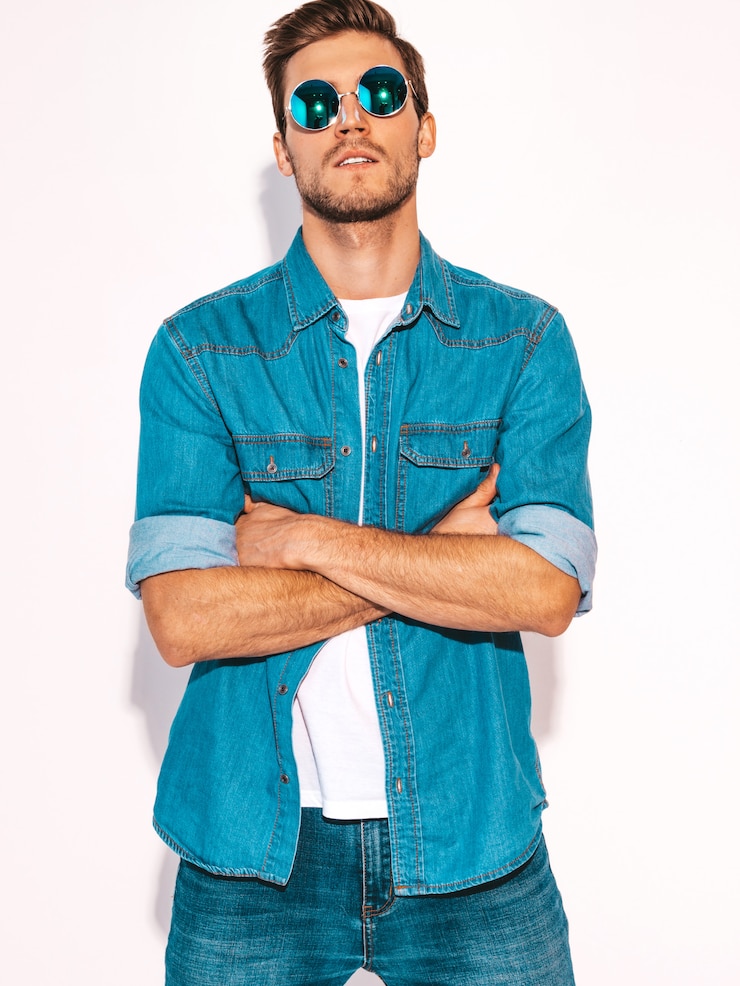 Gratis Foto portret van knappe lachende stijlvolle jonge man model gekleed in jeans kleding en zonnebril. mode man