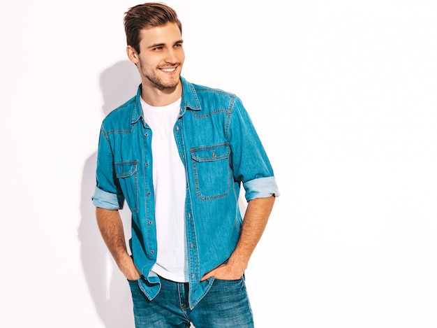 Portret van knappe lachende stijlvolle jongeman model gekleed in jeans kleding. Mode man