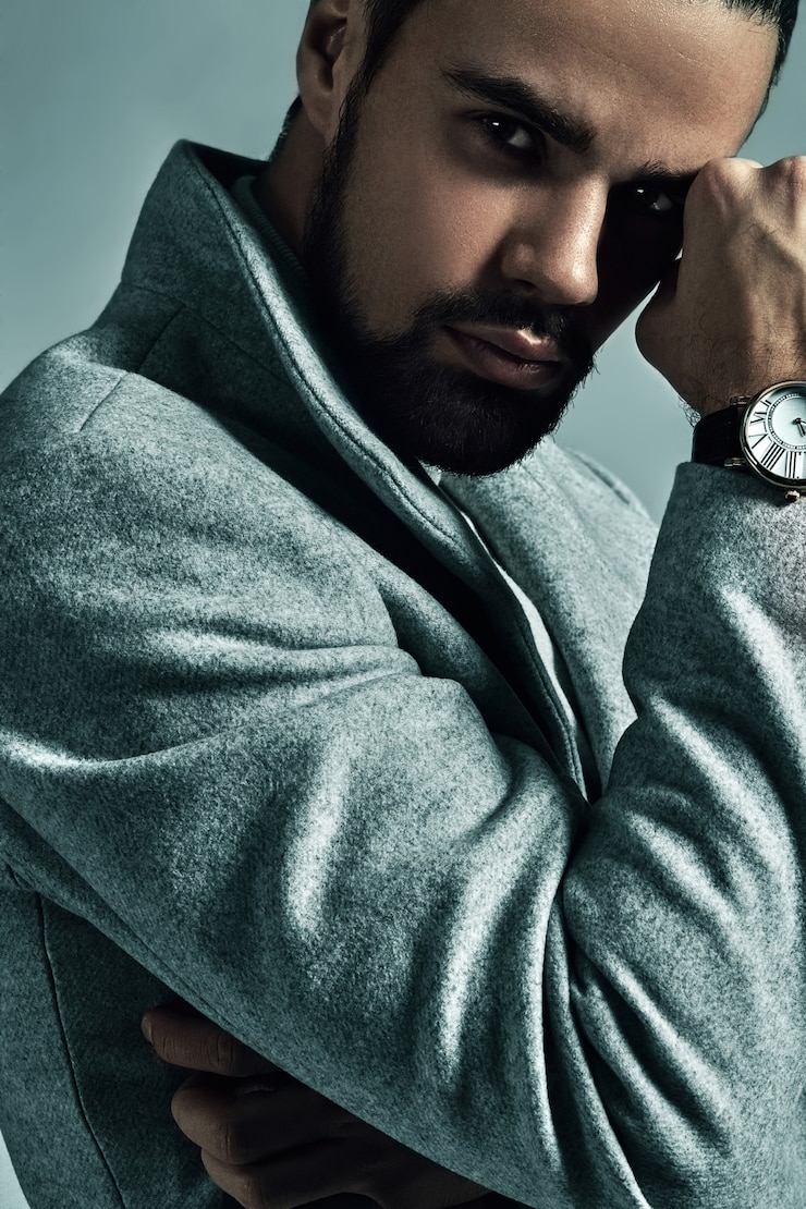 Gratis Foto portret van knappe mode stijlvolle hipster model gekleed in warme overjas poseren in studio.