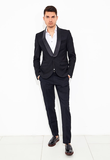 portret van knappe mode stijlvolle zakenman model gekleed in elegante zwarte klassieke pak poseren. metrosexual
