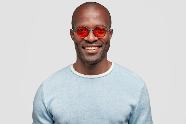 Portret van knappe vrolijke mannelijke manager in stijlvolle rode zonnebril