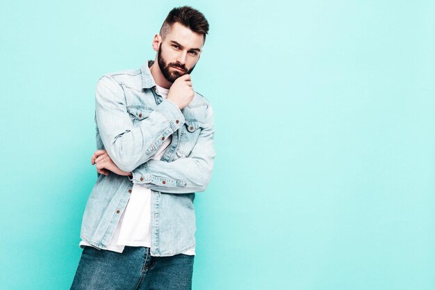 Portret van knappe zelfverzekerde model Sexy stijlvolle man Fashion hipster man poseren in de buurt van muur in studio
