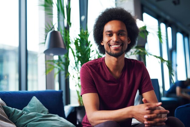 Portret van lachende Afrikaanse man in woonkamer