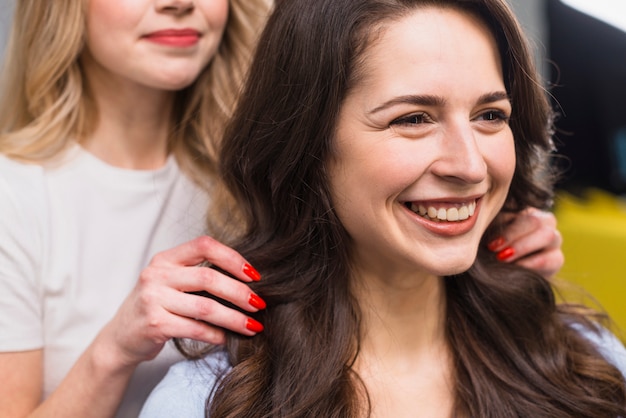 Portret van lachende jonge vrouw bij herenkapper