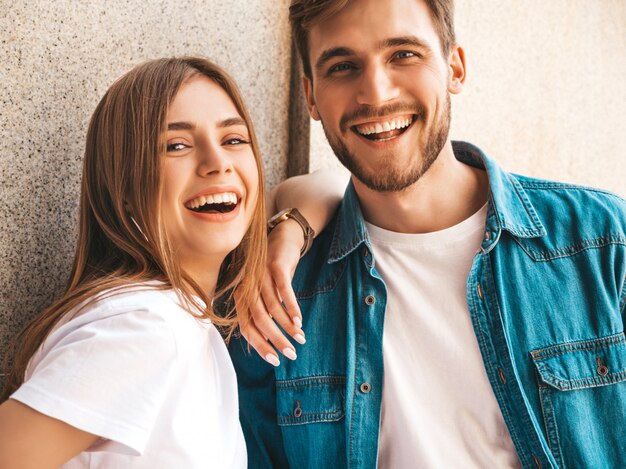 Portret van lachende mooi meisje en haar knappe vriendje. Vrouw in casual zomer jeans kleding. . Kijkend naar elkaar