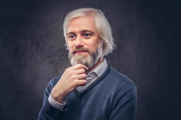 Portret van lachende oude man met een grijze baard geïsoleerd op een donkere achtergrond.