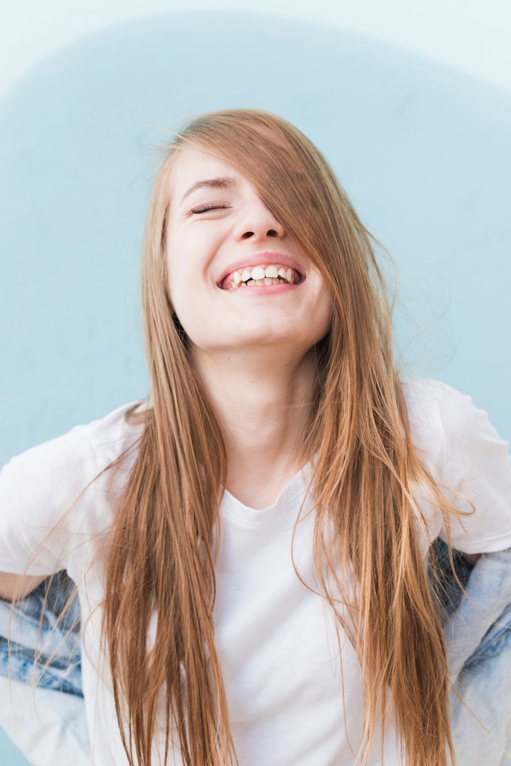 Gratis Foto portret van lachende stijlvolle jonge vrouw met gesloten ogen
