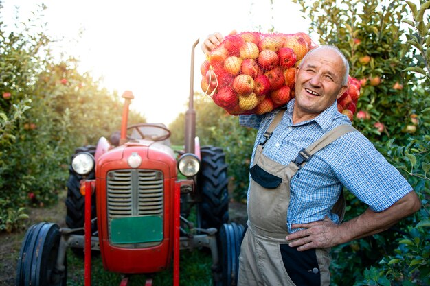 Portret van landarbeider bedrijf zak vol appelfruit