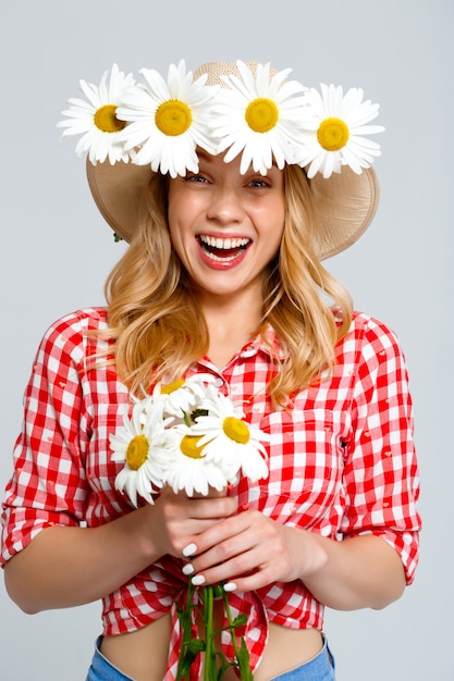 Portret van landvrouw met kamilles op grijs.