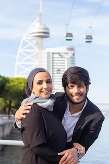 Portret van liefdevol arabisch paar. vrouw met bedekt hoofd en lichte make-up en man in pak camera kijken. liefde, genegenheid concept