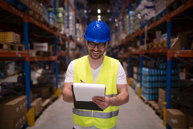 Portret van magazijnmedewerker in beschermende uniform goederen controleren voor distributie naar de markt