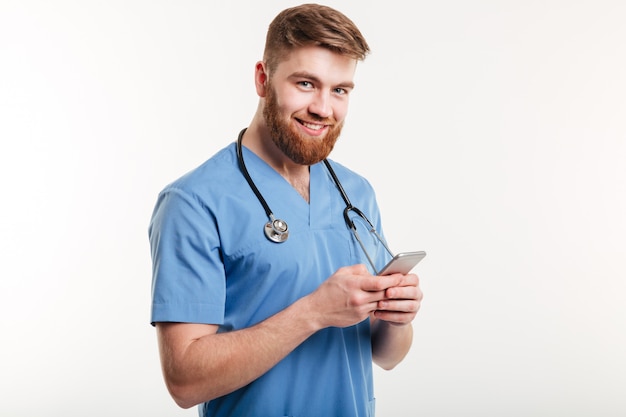 Portret van man arts met behulp van mobiele telefoon.