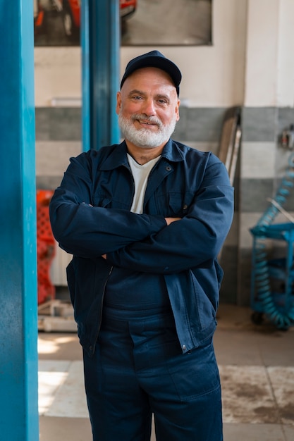 Gratis foto portret van mannelijke automonteur in de autoreparatiewerkplaats