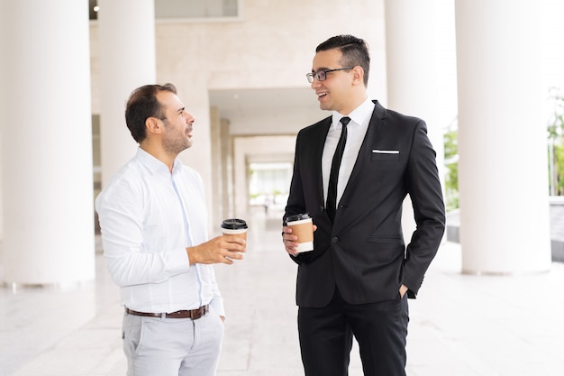 Portret van mannelijke bedrijfscollega&#39;s die koffie en het spreken drinken