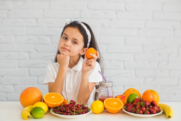 Gratis foto portret van meisje dat rijp fruit houdt