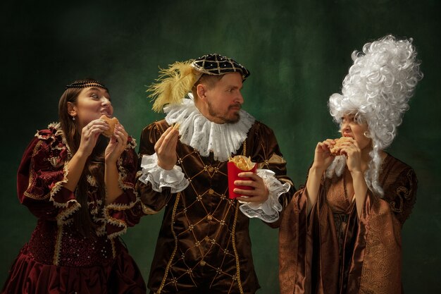 Portret van middeleeuwse jongeren in vintage kleding op donkere muur