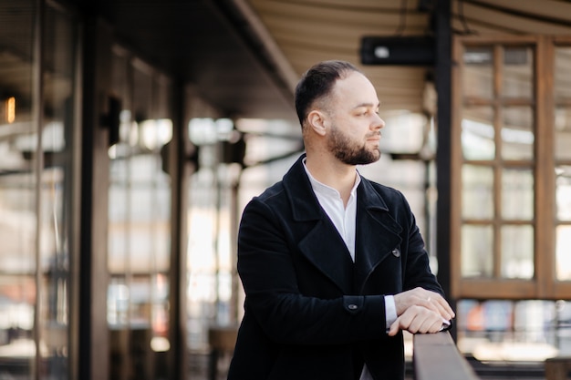 Portret van modieuze goed geklede man met baard poseren buitenshuis