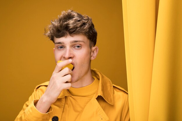 Portret van modieuze jongen die fruit eet