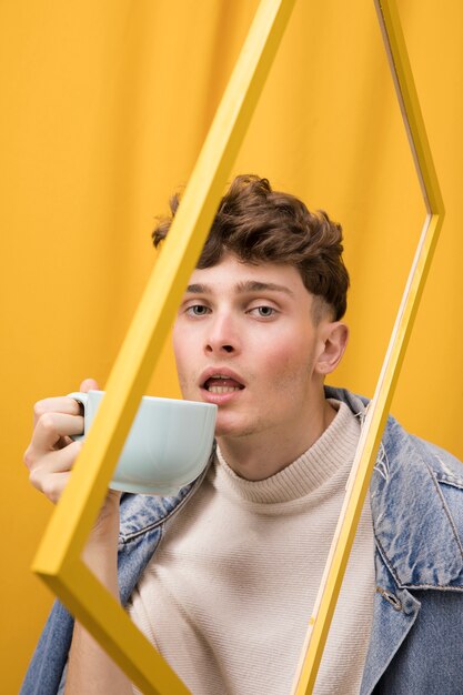 Portret van modieuze jongen drinken in een frame