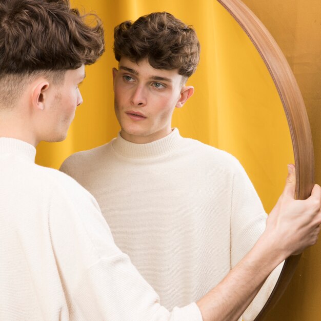 Portret van modieuze jongen voor spiegel