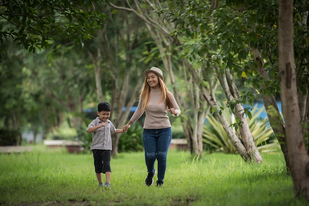 Portret van moeder en zoon gelukkig samen wandelen in de hand van de parkholding.