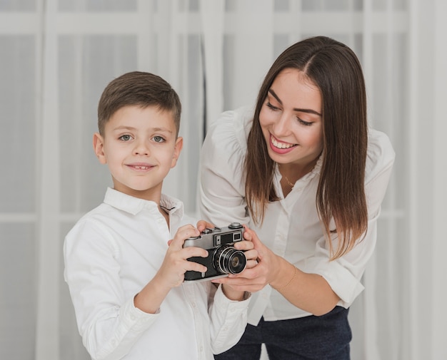 Gratis foto portret van moeder zoon leren hoe een camera te gebruiken