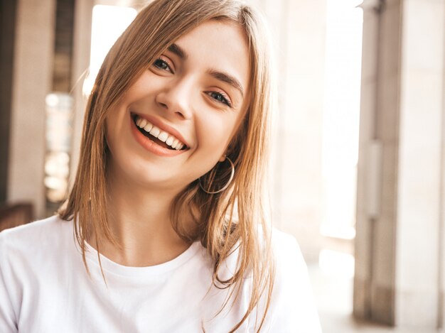 Portret van mooi glimlachend blond model gekleed in de zomer hipster kleren.