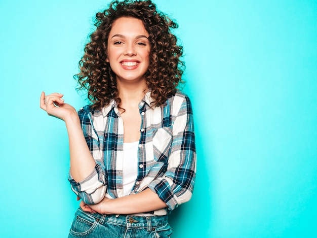 Portret van mooi glimlachend model met afro krullen kapsel gekleed in de zomer hipster kleding. Trendy grappige en positieve vrouw