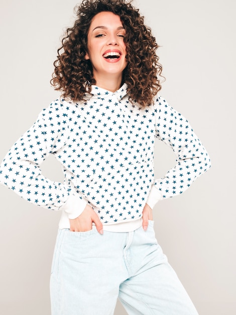 Portret van mooi glimlachend model met afro krullen kapsel gekleed in zomer hipster kleding. Sexy zorgeloos meisje poseren in studio op grijze achtergrond. Trendy grappige en positieve vrouw