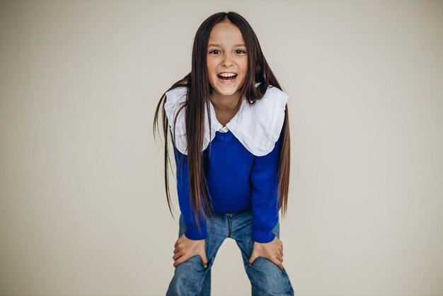 Portret van mooi jong meisje dat emoties toont die in studio worden geïsoleerd