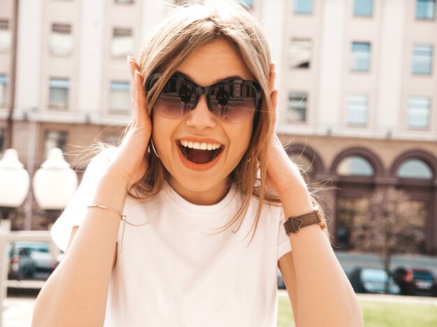 Portret van mooi verrast blond model gekleed in de zomer hipster kleren. het trendy meisje stellen op de straatachtergrond. grappige en geschokte vrouw