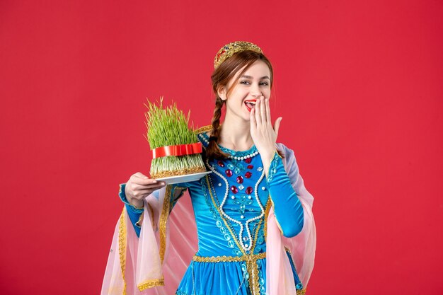 Portret van mooie Azerbeidzjaanse vrouw in traditionele kleding met semeni op rood