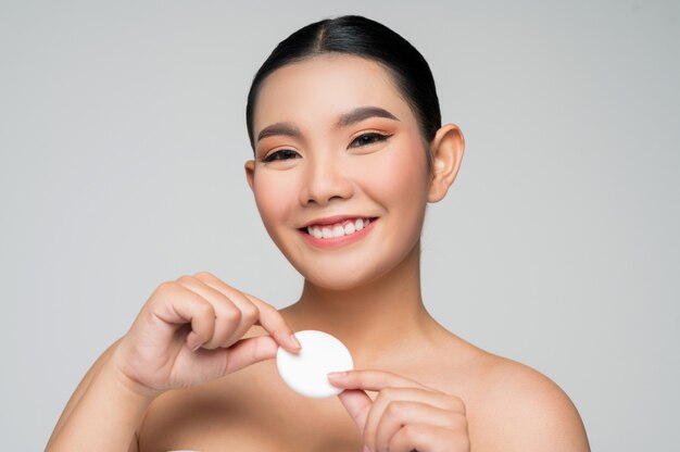 Portret van mooie Aziatische vrouw met foundation of kussen spons puff
