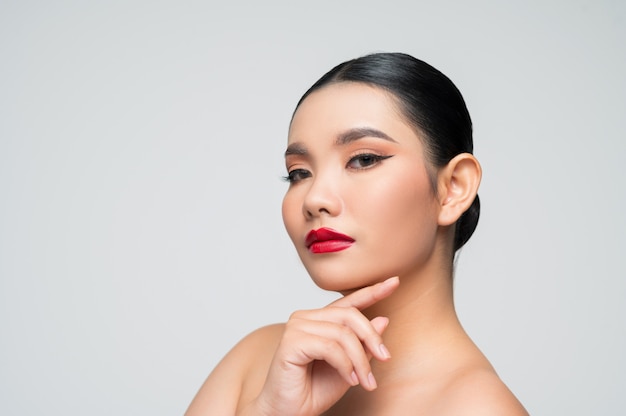 Portret van mooie Aziatische vrouw met zwart haar en rode lippen