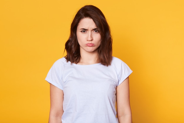 Portret van mooie donkerharige jonge vrouw in casual witte t-shirt