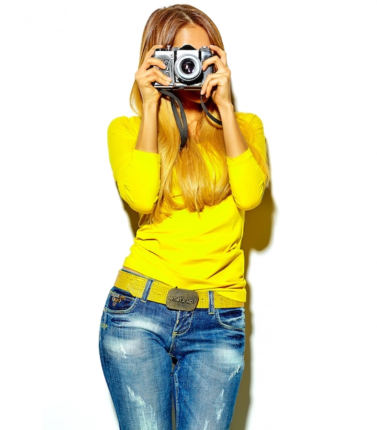 portret van mooie gelukkige schattige lachende blonde vrouw meisje in casual zomerkleren neemt foto's met retro fotografische camera
