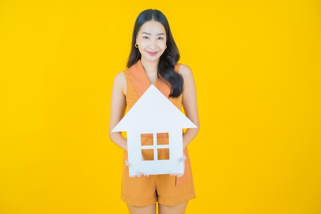 Portret van mooie jonge aziatische vrouw met huis of huispapierteken