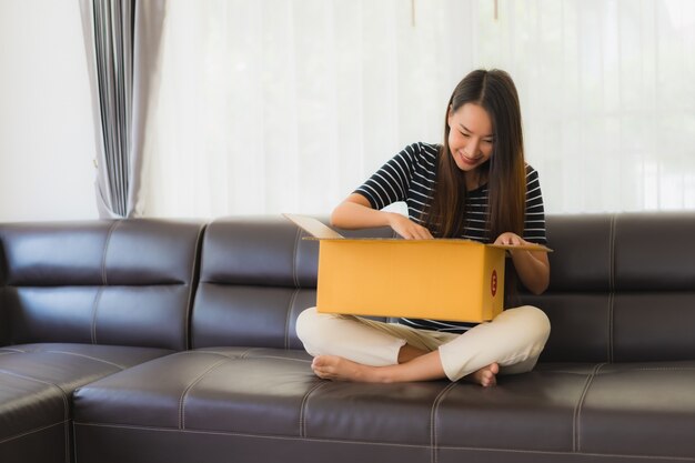 Portret van mooie jonge Aziatische vrouw met kartonnen pakket box