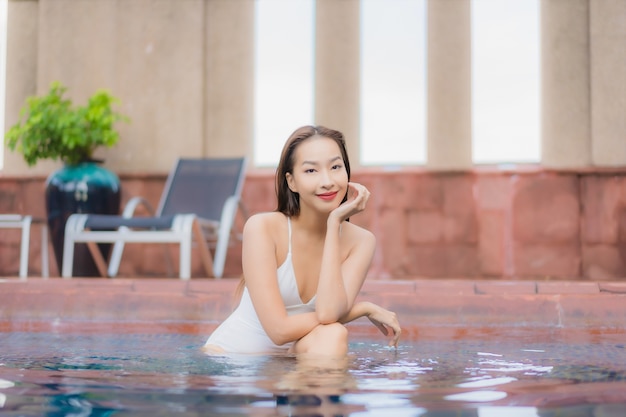 Portret van mooie jonge Aziatische vrouw ontspant in het zwembad