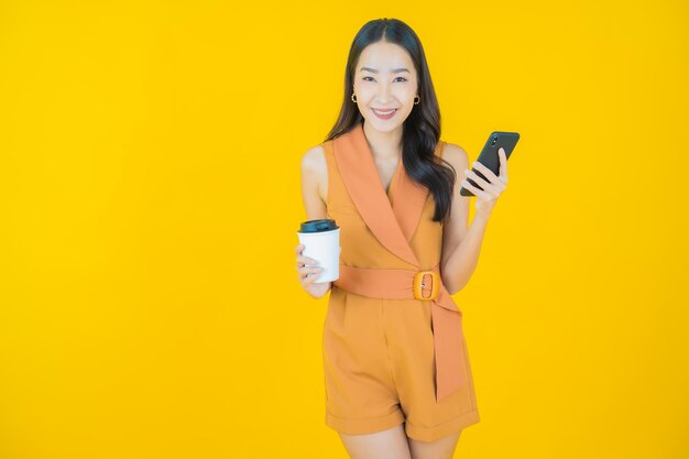 Portret van mooie jonge Aziatische vrouwenglimlach met slimme mobiele telefoon