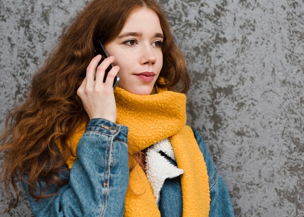 Portret van mooie jonge vrouw die op de telefoon spreekt